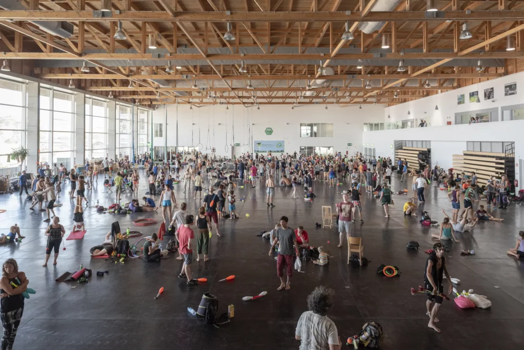 A big gym half full with jugglers training