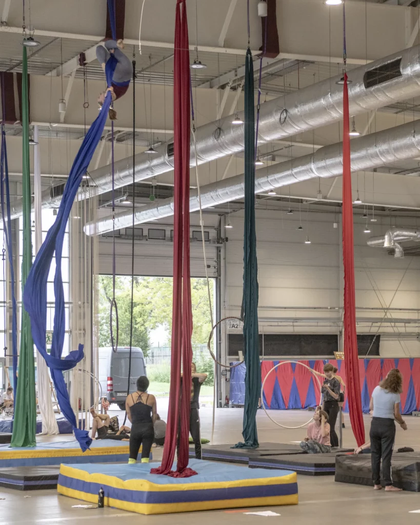 Areal acrobats training with silk hanging from the ceiling